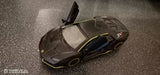Alloy sport car model toy in dark gray with yellow accents, side view