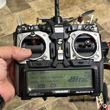Handheld drone remote controller with LCD screen, joysticks, and two antennas