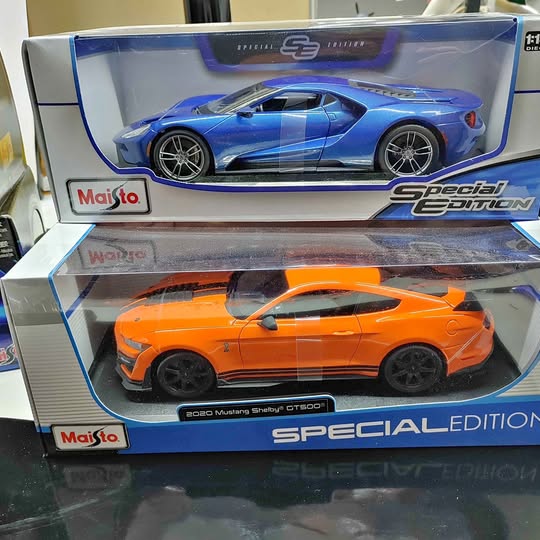 Orange 1/18th diecast model car with black wheels, shown in box