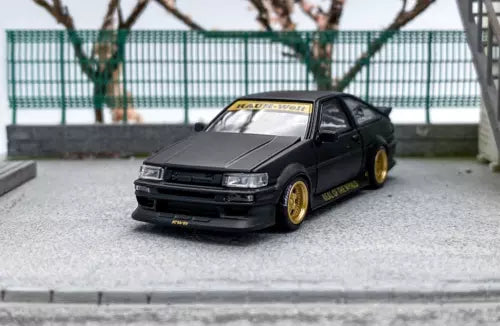 Black JDM widebody sports diecast model car with gold wheels and front view