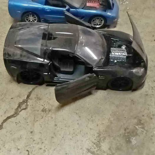 Black diecast sports car with silver hood detail and open door