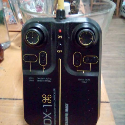 DX-1 remote controller with dual joysticks, ON/OFF switches, and control buttons