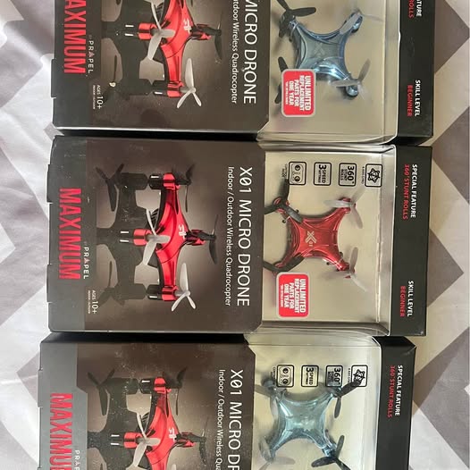 Red and blue micro drones in retail boxes, with four-blade propellers