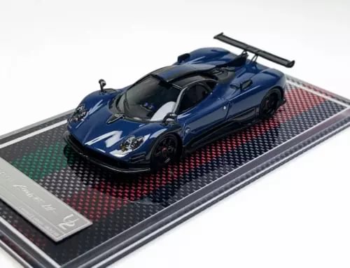 Blue racing sports diecast model car with rear wing on patterned display base