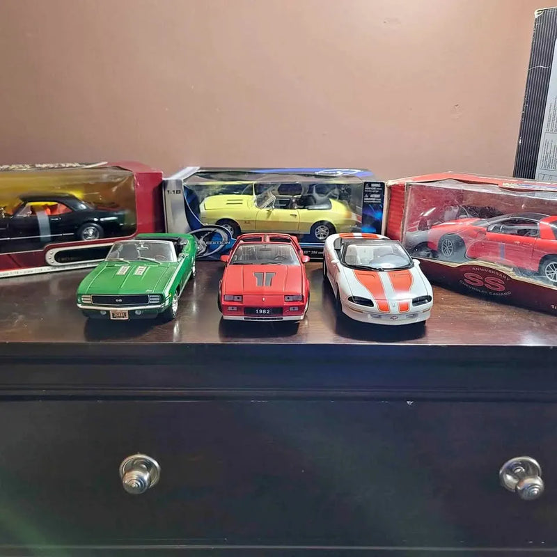 1/18 scale diecast Camaro model cars, assorted colors, front views on display shelf