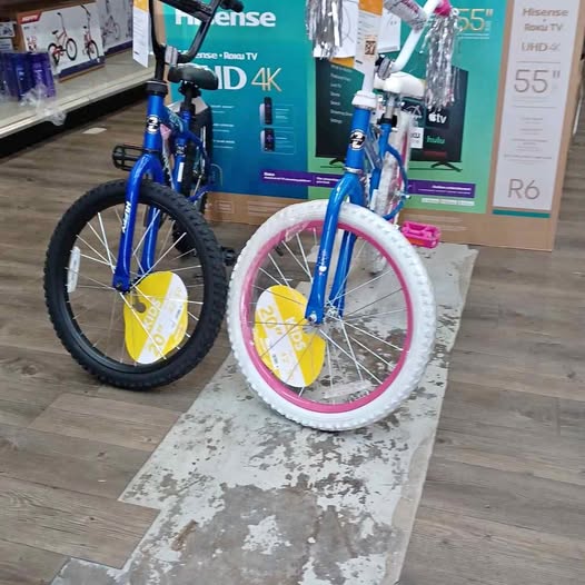 Kids bicycle with blue frame, pink front wheel and black rear tire