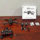 Black quadcopter drone kit with remote controller, extra parts, and cables.