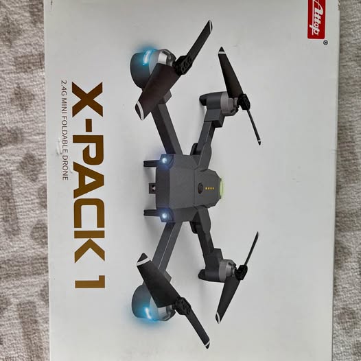 Small quadcopter drone with blue LED lights, folding arms and front propellers