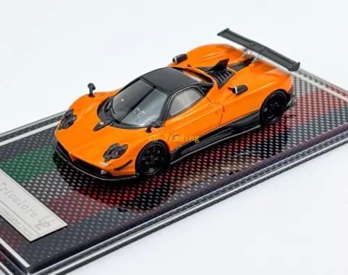 Orange racing sports diecast car model with black wheels and rear wing