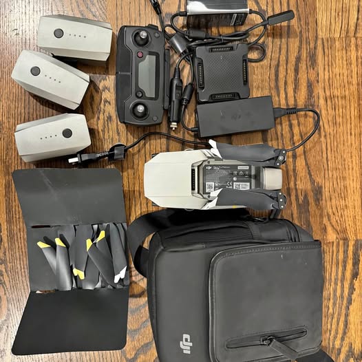 Black-and-gray drone case with batteries and controller accessories, plus spare shells