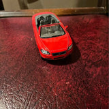 Red diecast convertible model car, front view with grille and headlights