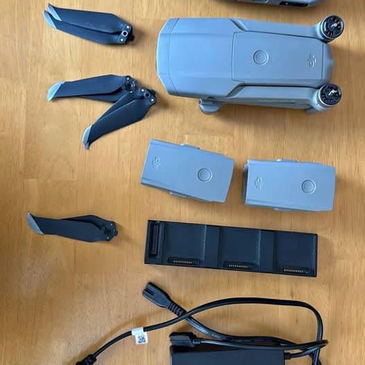 Blue foldable drone body with propellers and spare parts