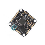 FPV flight controller circuit board with orange solder pads and microchip