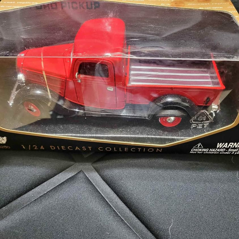 Red 1/24 diecast pickup truck with extended cab and open bed, front 3/4 view