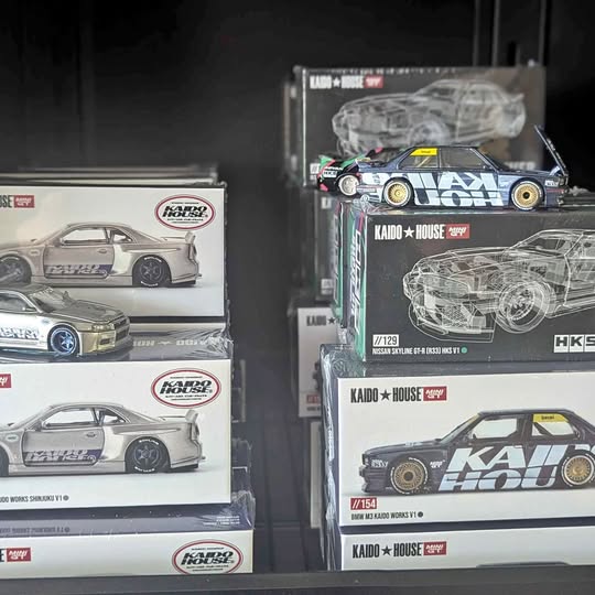 Boxed diecast race car models with gray and black cars in clear window packaging