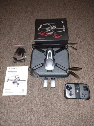 Gray quadcopter drone with camera, remote controller, and user manual