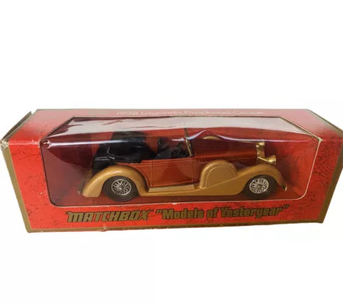 Diecast car model in red Matchbox display box, vintage roadster with tan body