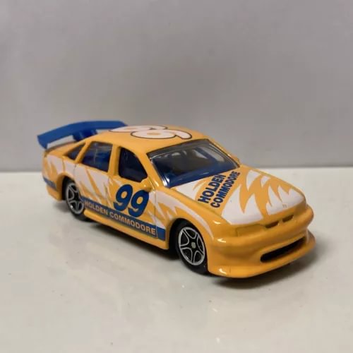 Yellow 1/64 diecast Holden Commodore VT race car with flame decals and #99 graphics