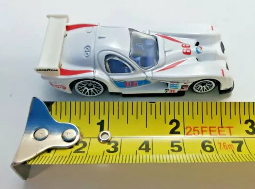 White race car diecast with red stripes and blue decals, front-side view
