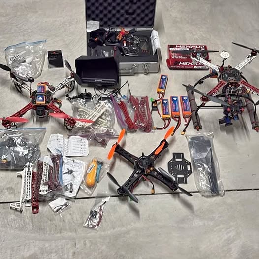 DJI FPV quadcopter drone kit with black frame, red arms, and included parts