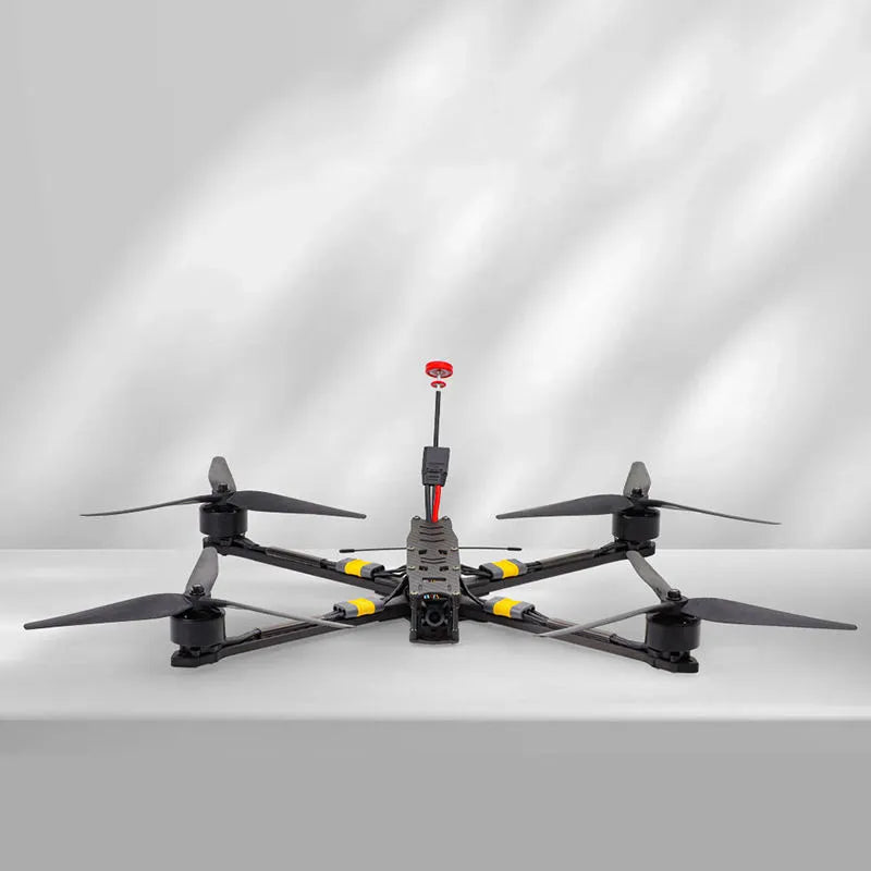 Quadcopter drone with 4 propellers, black body with yellow accents and red cap