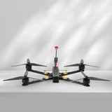 Quadcopter drone with 4 propellers, black body with yellow accents and red cap