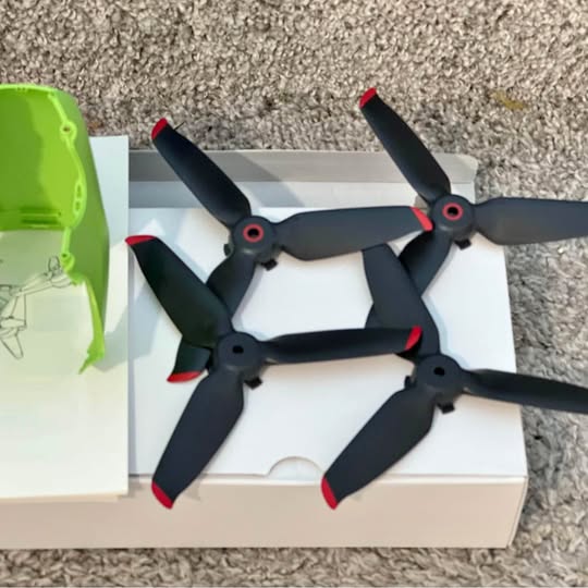 FPV drone propellers with black blades and red tips, green body panel