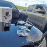 Drone with remote controller and spare parts on a car hood