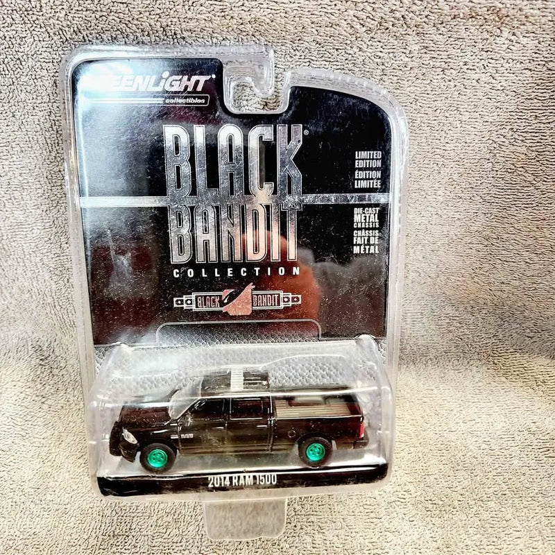 Diecast model pickup truck in clear box, black with green wheels