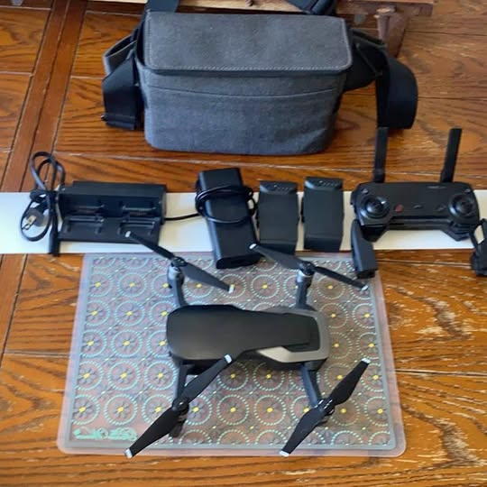 DJI Mavic Air drone with controller and carrying case, laid out on mat