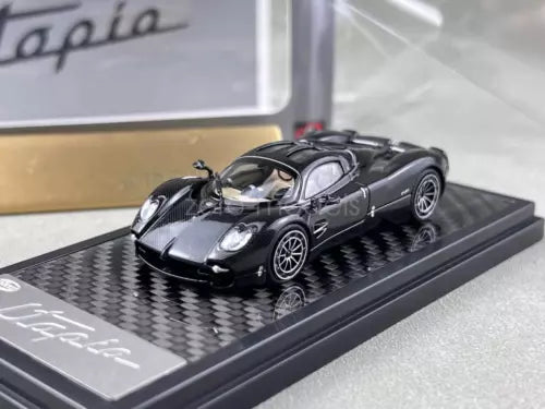 Black diecast sports coupe model with glossy finish on black display base