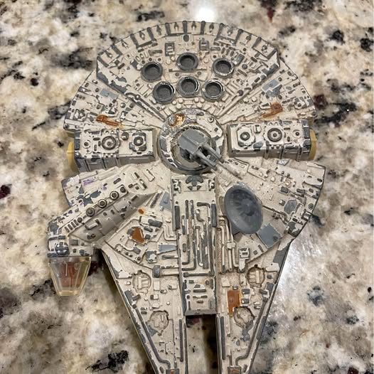 Metallic silver diecast toy spaceship model with detailed circular panel