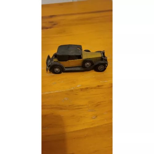 Gold and black vintage diecast toy car, 1930 style, front three-quarter view