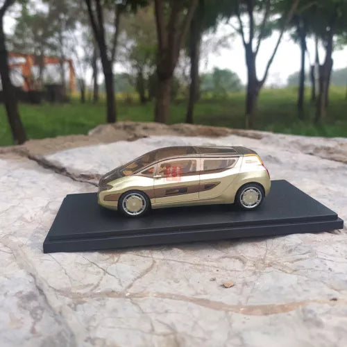 Gold and black diecast model car on display base, 1:43 scale