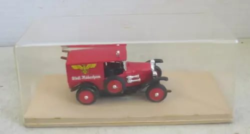 Diecast fire engine model, red vintage truck with front grille and ladder, in display case