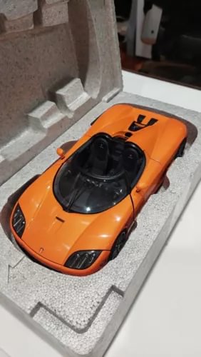 Orange diecast sports car model with black cockpit and front grille