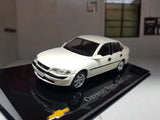 White diecast model car, front 3/4 view on black display base