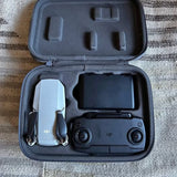 DJI drone in gray hard case with remote controller and landing accessories
