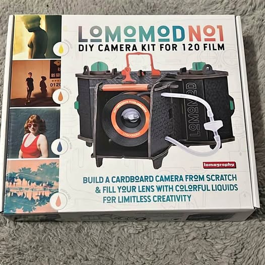 DIY camera kit box with illustrated camera and orange lens detail