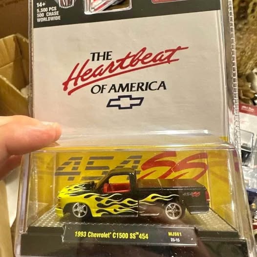 Die-cast Chevrolet C1500 SS toy truck, yellow with flame graphics, in display box