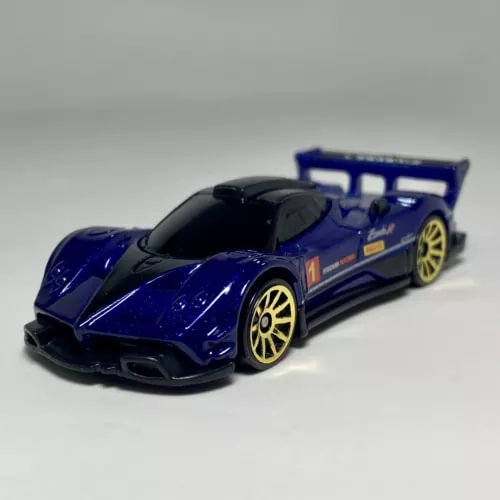 Blue and black 1:64 scale diecast model car with gold wheels and rear spoiler.