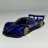 Blue and black 1:64 scale diecast model car with gold wheels and rear spoiler.
