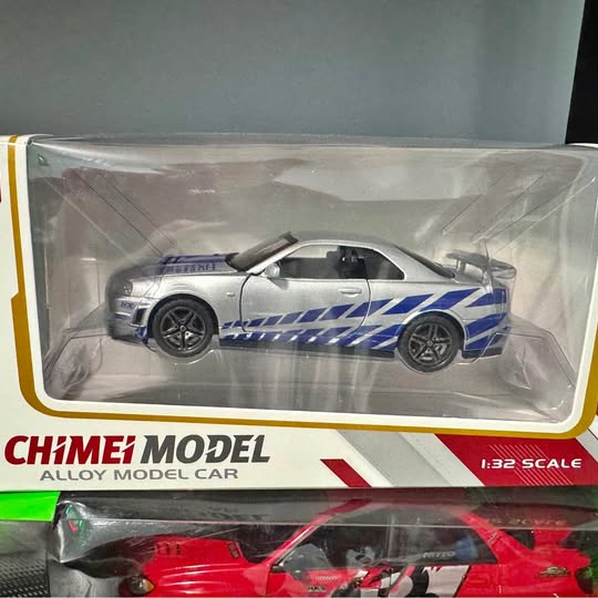 Blue and white diecast sports car model in clear display box, 1:32 scale