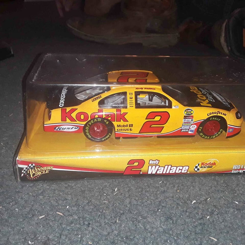 Yellow diecast race car with number 2 graphics in display case