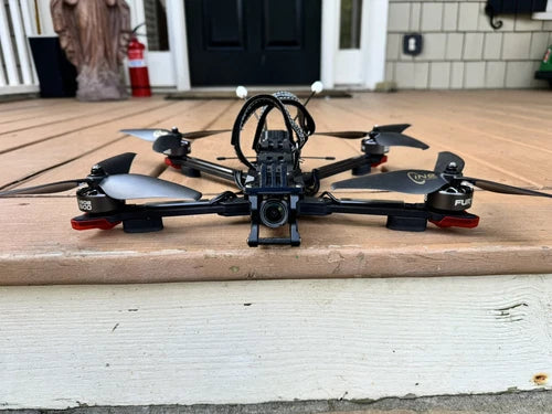 FPV racing quadcopter drone with central camera and four arms, black frame