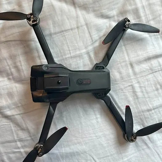 Quadcopter drone with four fold-out propellers, dark gray body and front camera housing