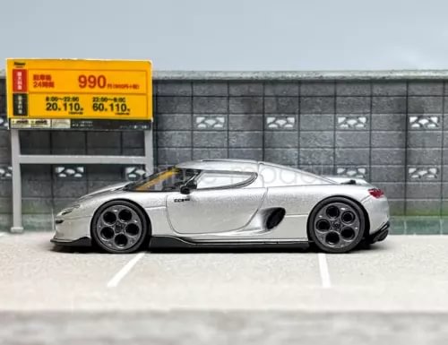 Silver diecast sports race car model, low stance with black wheels and rear spoiler.