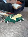 Green convertible diecast car toy with open top and beige interior