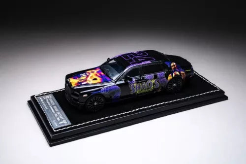 Diecast model car toy in black and purple with flashy graphics, on display base