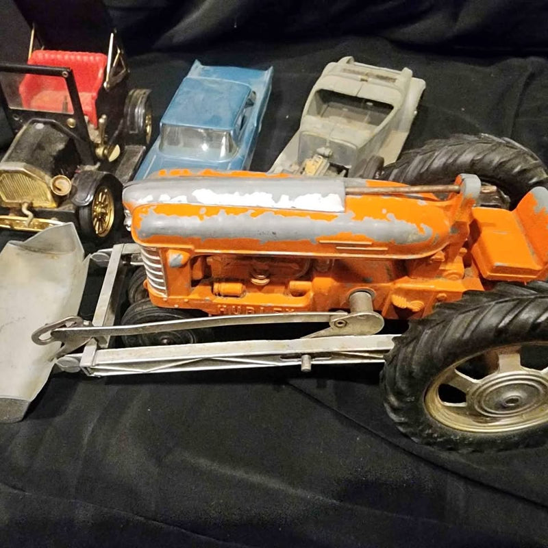 Vintage diecast tractor, orange with white stripe, front view with large tires
